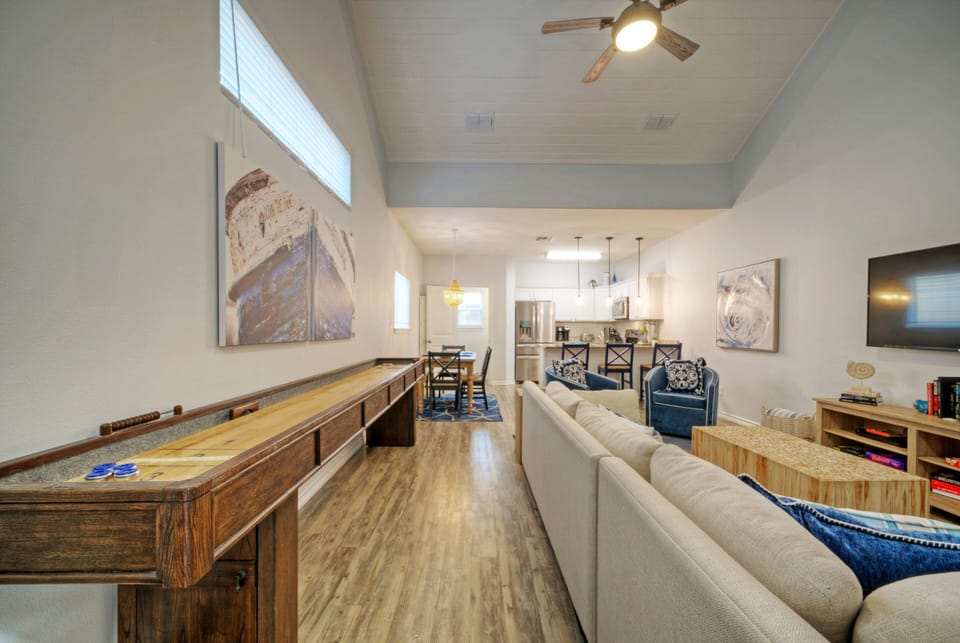 Spacious living area features a shuffleboard table.