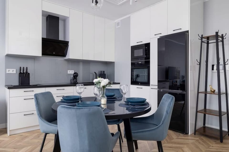 Dining area and kitchenette with an induction hob, fridge with freezer, oven, microwave, electric kettle, coffee maker and dishwasher.