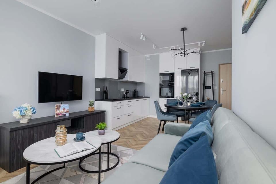 Living area equipped with a double sofa bed, Smart TV, exit to balcony and kitchenette.