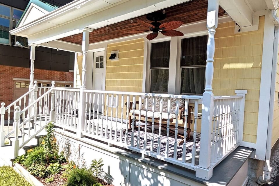 Front Porch, ceiling fan, glider & string lights. Native flowerbed.