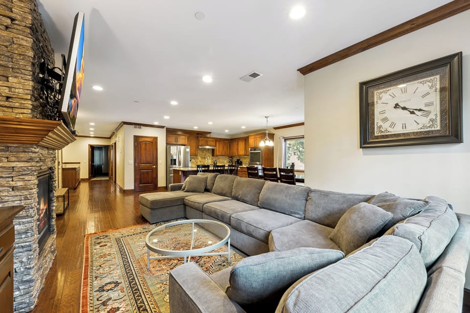Sink into this plush sectional sofa by the stone fireplace, where your evenings unfold in warmth and comfort.