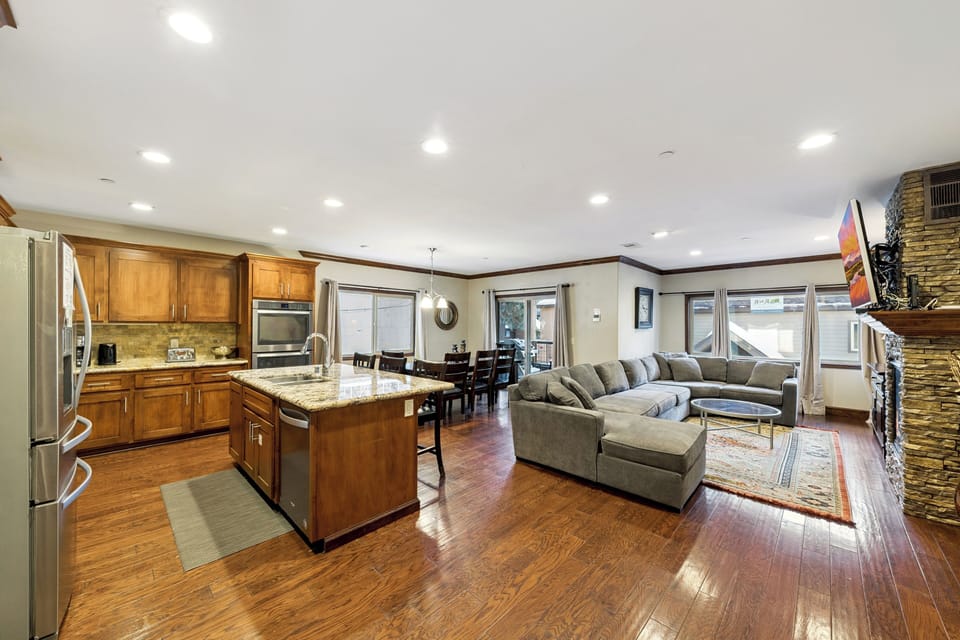Step into your spacious open-plan retreat where gleaming hardwood floors connect a gourmet kitchen with granite counters to your cozy living area with stone fireplace.