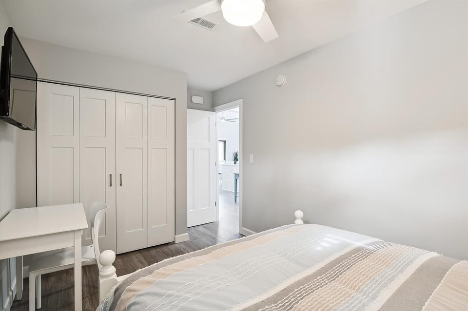 Relax in your bright, airy bedroom with ceiling fan and ample closet storage. Soft linens and modern touches ensure your comfortable stay in this peaceful retreat.