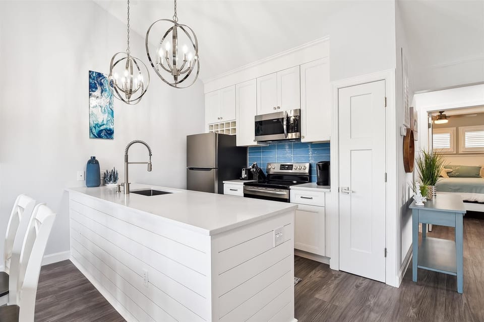 A bright, welcoming kitchen awaits you with modern appliances, a spacious island, and elegant chandeliers overhead. Cook your favorite meals in this inviting space with plenty of counter room and storage.