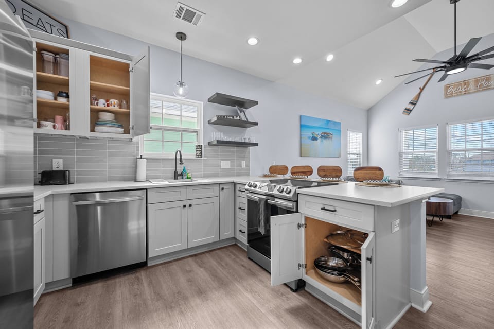 Cabinets are fully stocked with dishes, cookware, glasses and cups.