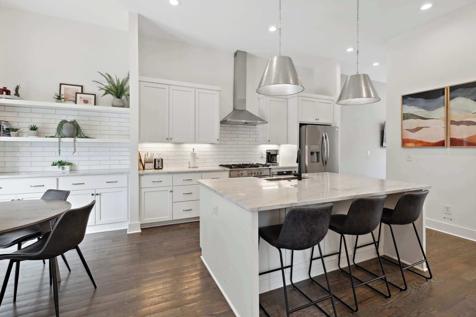 Elegant white kitchen with a 3-seat island and side dining table for easy entertaining.