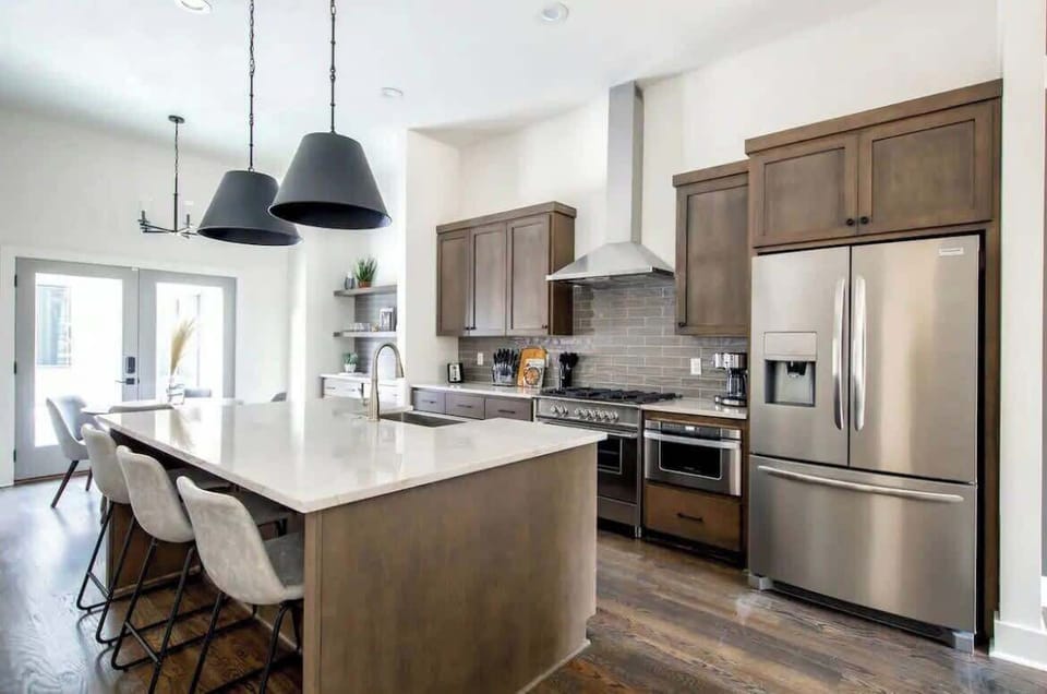 Modern kitchen with stainless steel appliances and brown finishes.