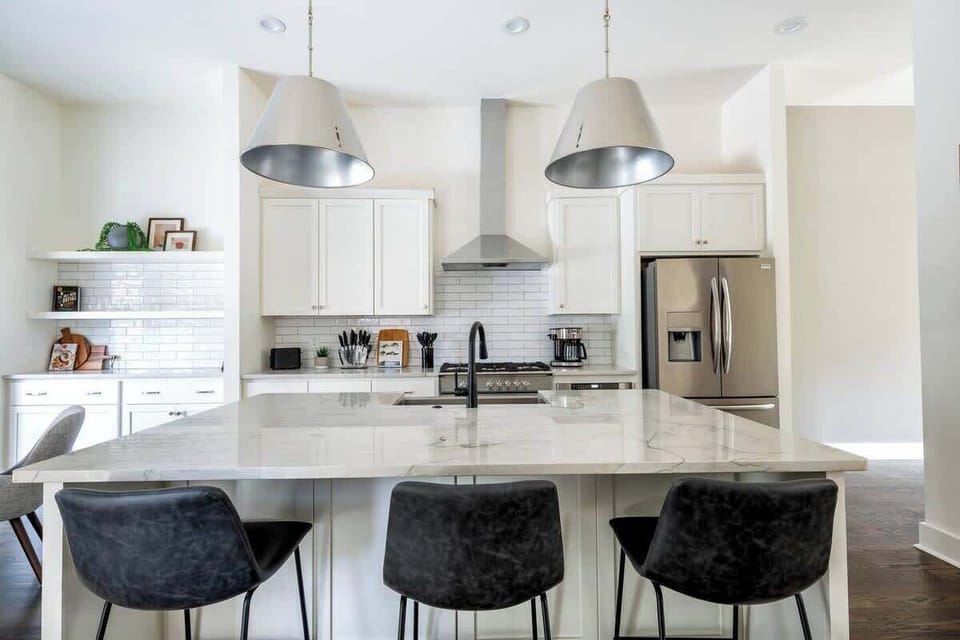 Fully equipped kitchen featuring stainless steel appliances and a 3-seat island.