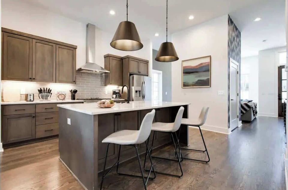 Stylish kitchen with warm wooden cabinets, stainless appliances, and a 3-seat island.