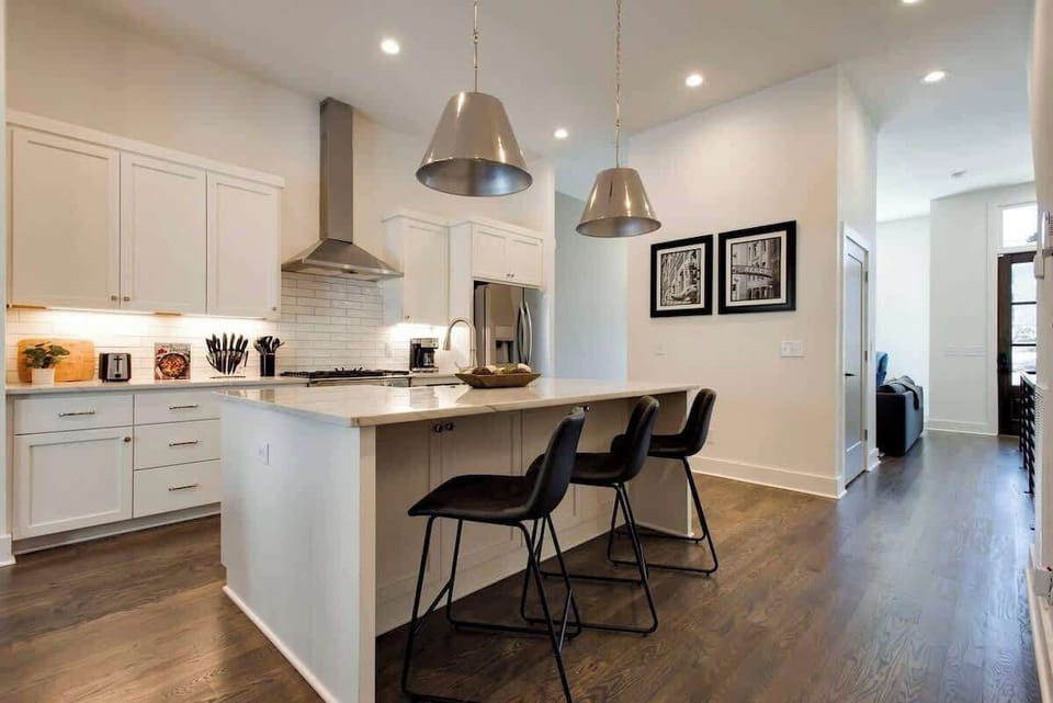 White kitchen fully stocked with stainless steel appliances.