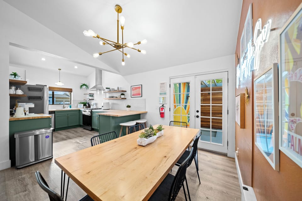 Dining room with table and six chairs. Two more seats at the kitchen counter