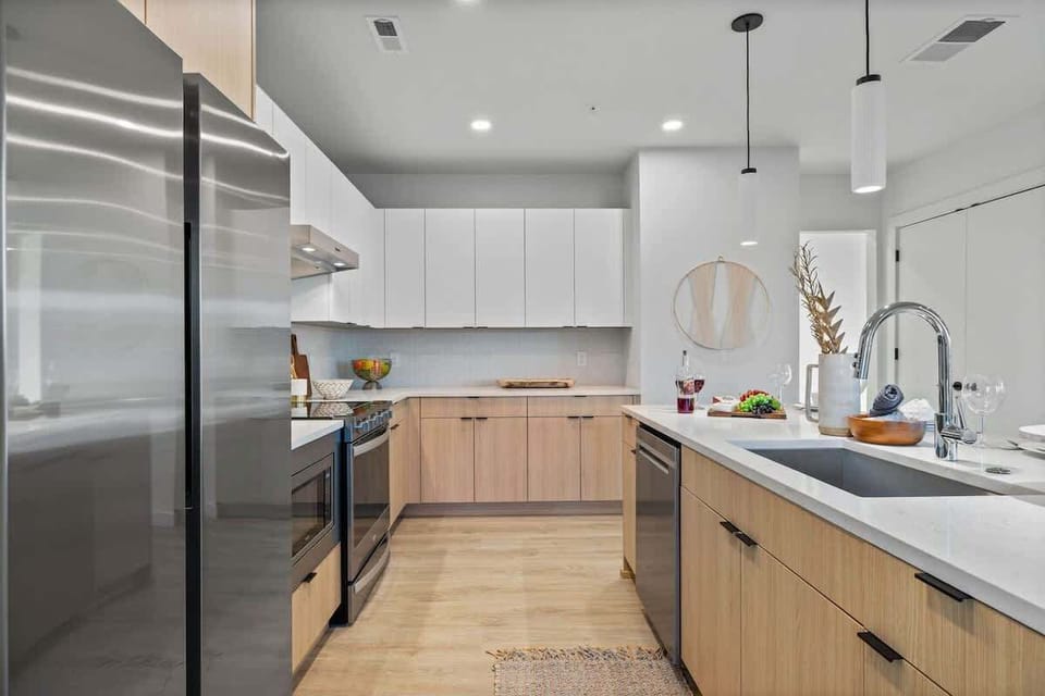 Fully equipped modern kitchen featuring culinary essentials, stainless steel appliances, and island bar seating.