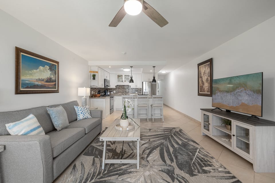 Cozy living room with plush sofa and easy access to kitchen and dining.
