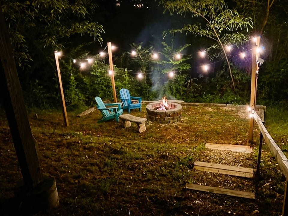 Private backyard fire pit with string lights and cozy seating