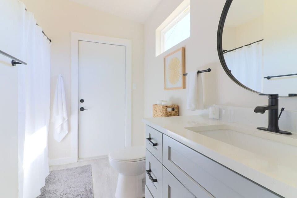 Immaculate bathroom offering a well-stocked oasis. Find essentials at your fingertips - plenty of toilet paper, a hair blowdryer, and plush towels. Convenience meets luxury with complimentary cotton balls and cotton swabs.
