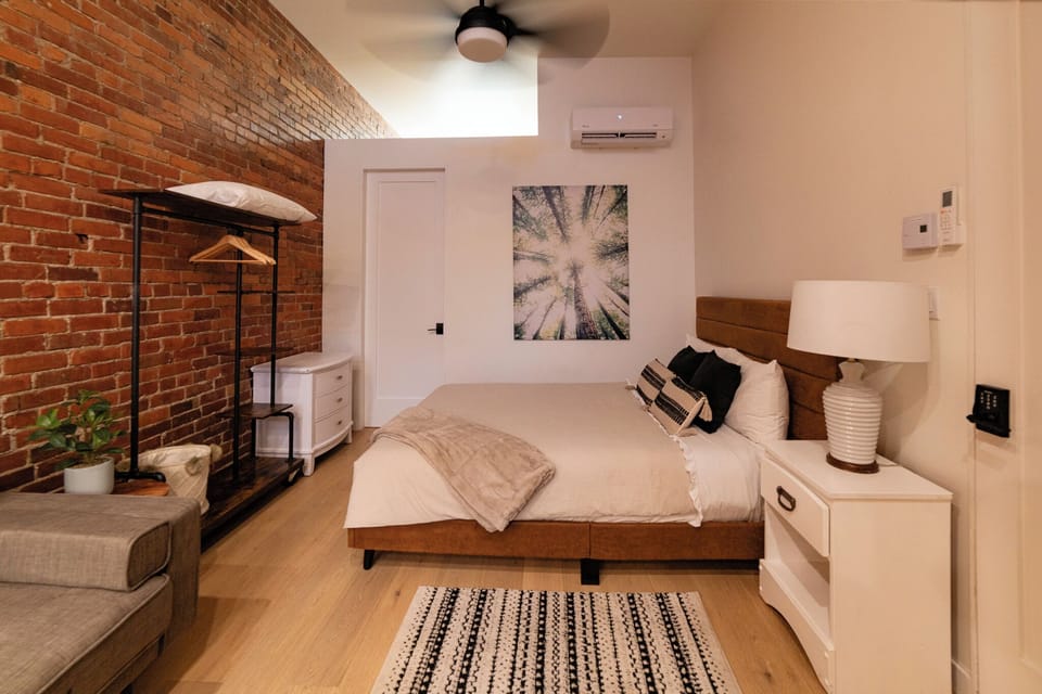 Comfortable queen size bed near door to the bathroom.