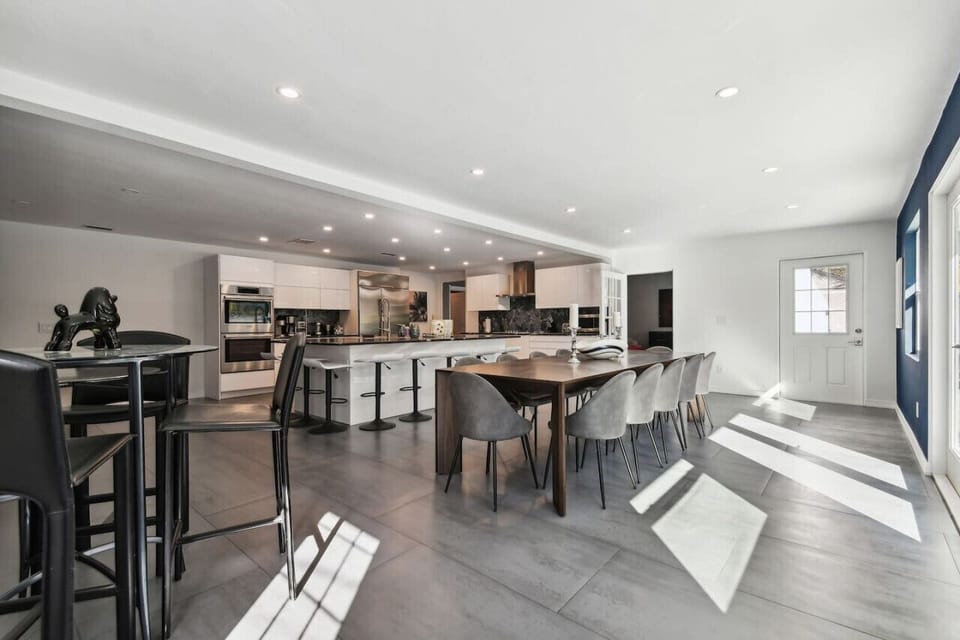Open-space kitchen with high-end luxury appliances and dining area seating 14