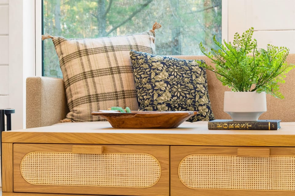 A warm plaid pillow and a richly patterned cushion