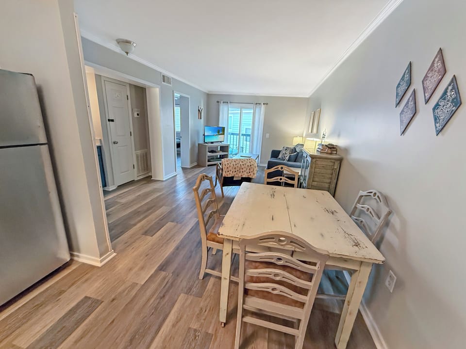Bright open living-dining with rustic charm and balcony access