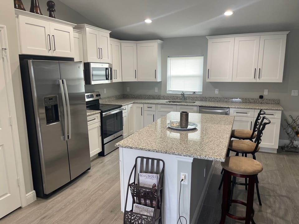 OPEN LIVING ROOM, DINING ROOM, AND KITCHEN WITH BIG BEAUTIFUL ISLAND.