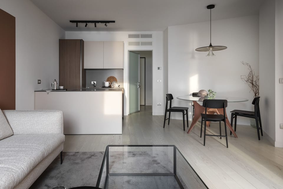 Luxurious living room at Portopiccolo Apartments - Pearl in the Village. Ideal for couples, families, and business trips. A luxury apartment, fully equipped and furnished with every comfort. Characterized by a breathtaking sea view. Featuring two bedrooms and two bathrooms with showers, accommodating up to four people. It comes with a fully equipped kitchen and indoor and outdoor dining areas. The apartment is complemented by WiFi and reserved covered parking.