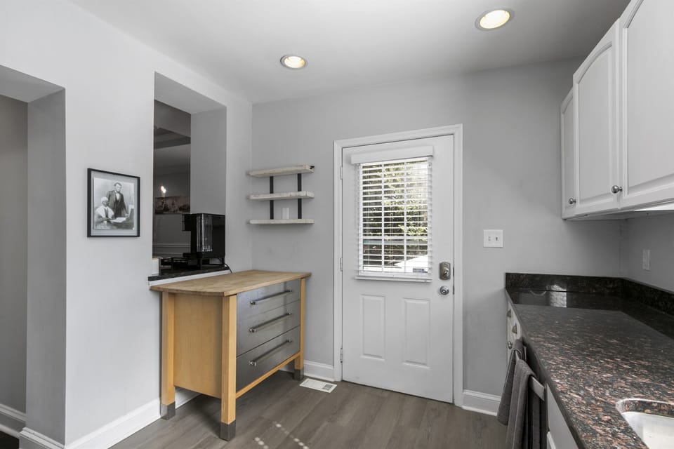 Kitchen door opens onto backyard patio, extending culinary delights outdoors.