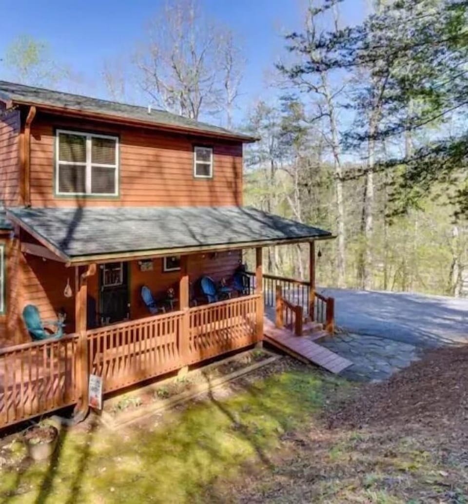 Private North Georgia mountain cabin surrounded by trees, featuring a spacious deck and peaceful wooded views.