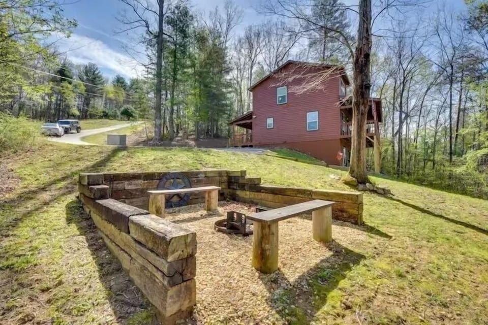 Private outdoor fire pit area with built-in seating, perfect for evening gatherings in a peaceful wooded setting.