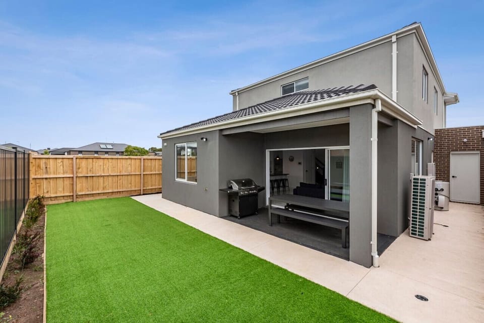 Enjoy outdoor living in this low-maintenance backyard, complete with a covered alfresco dining area, BBQ, and lush synthetic turf, perfect for relaxed meals and family fun