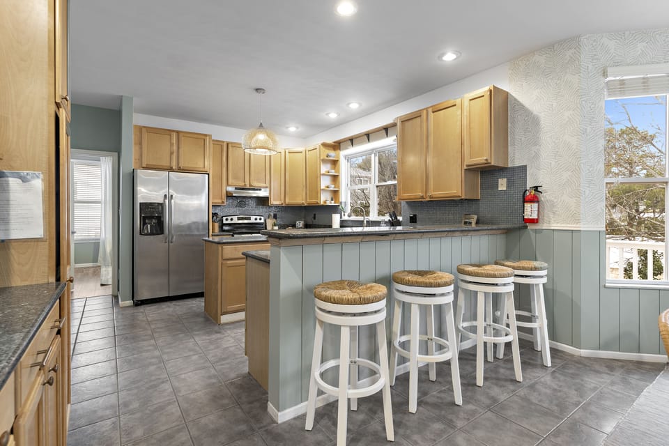 Open, fully stocked kitchen with bar seating for 4