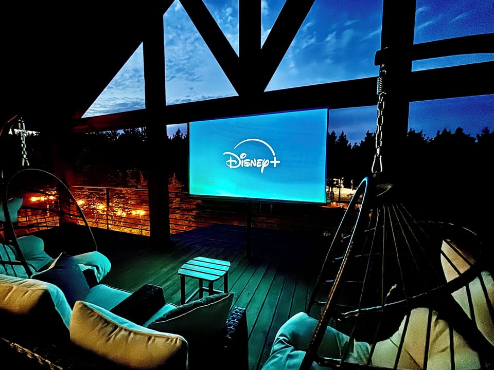 Cozy outdoor movie night with stunning views and comfy hanging chairs.
