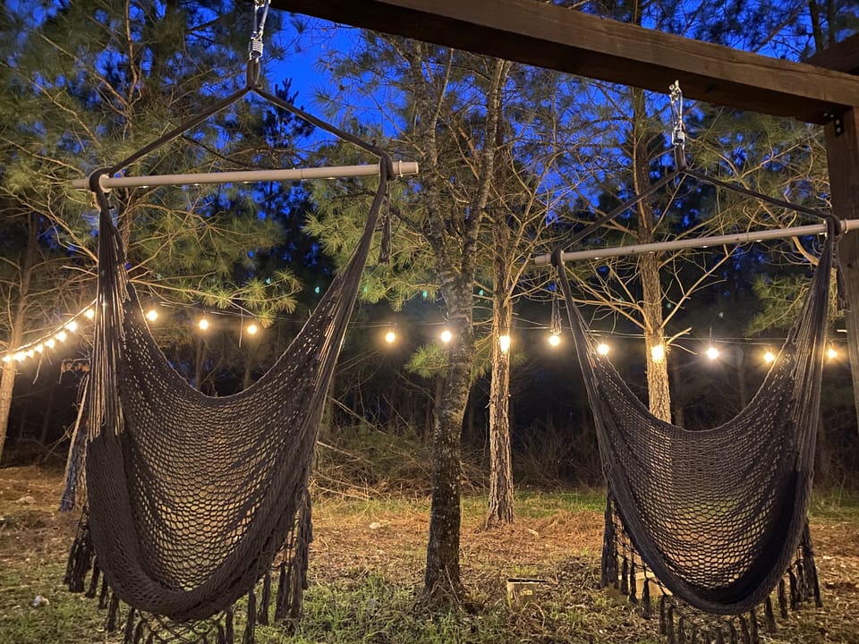Cozy hammock chairs under string lights—perfect for a relaxing evening outdoors.