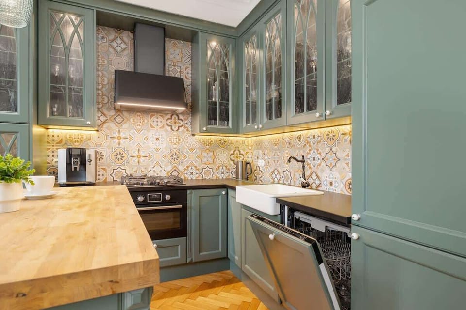 A wide shot of the kitchen, showcasing the spacious layout, an island with seating, and plenty of natural light.