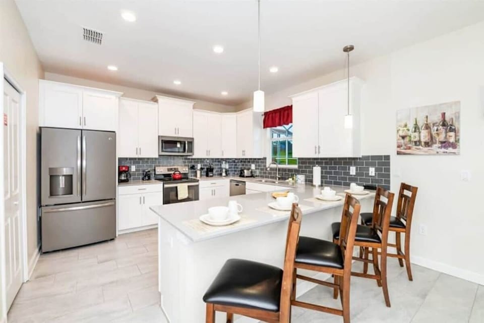 A spacious breakfast bar with four stools for additional seating at meal time.