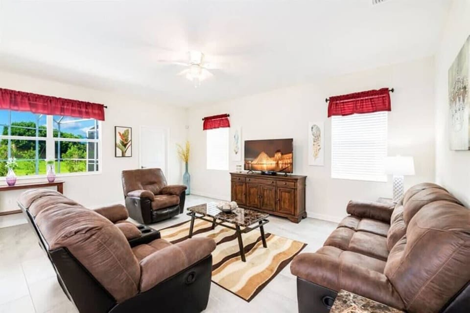 Featuring cozy recliner sofas and a large flatscreen TV.