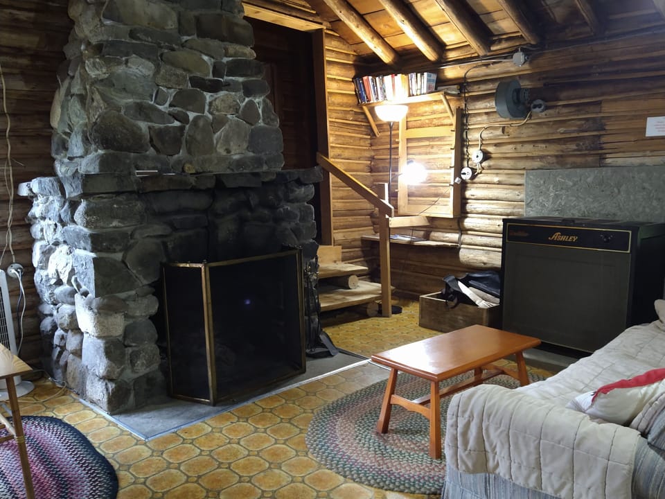 Living room, fireplace, woodstove, stairs to bedrooms and bathroom