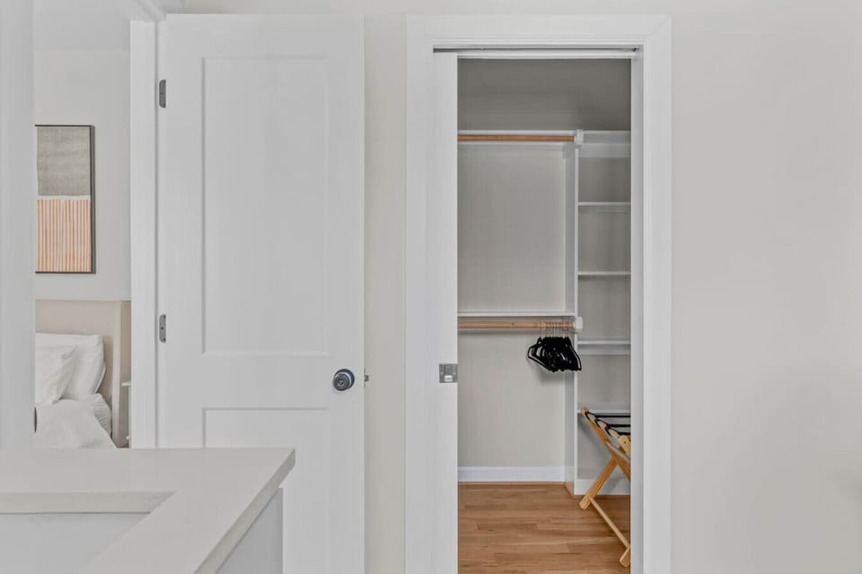 Master bathroom has a large walk in closet with hangers and luggage stand