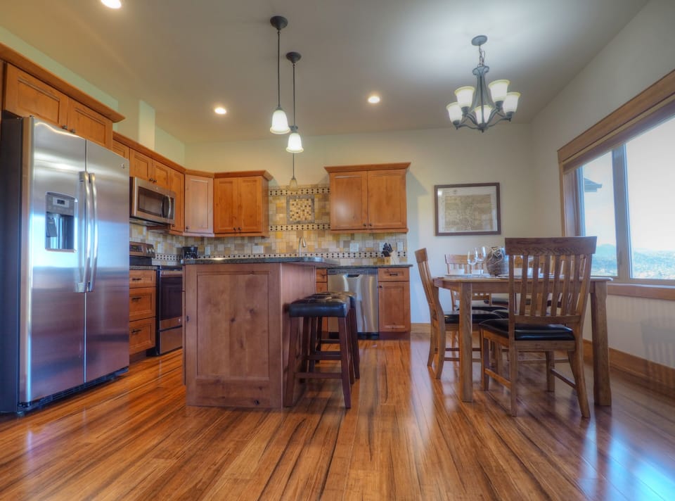 Open concept kitchen and dinning table for 6, Large refrigerator, and electric stove.