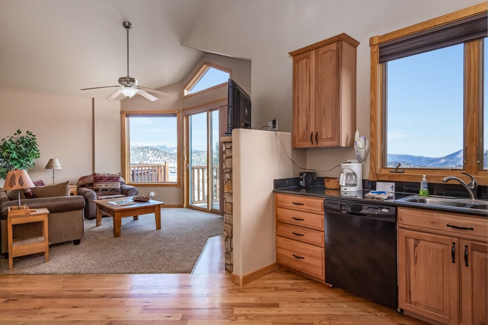 Open concept living area. Ceiling fan in living room. Kitchen has dishwasher, drip coffee maker