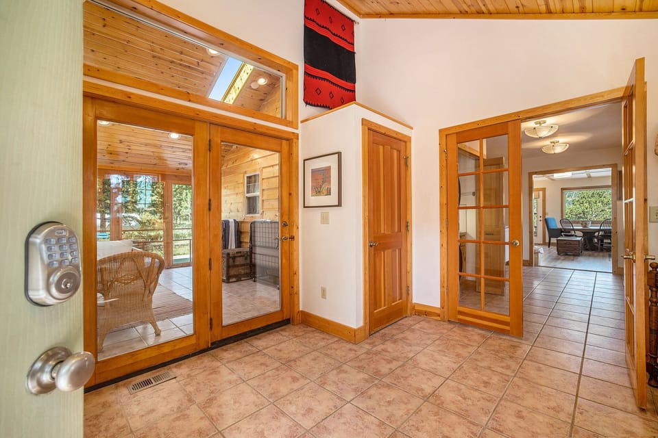 Kittery West Estes Park, Entryway with doors to screened patio area, and hallway that leads to kitchen and living room.