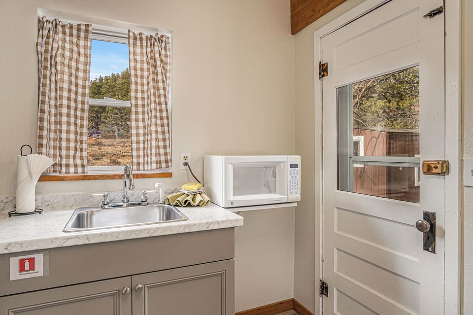 Kitchen with microwave, door to access the deck.