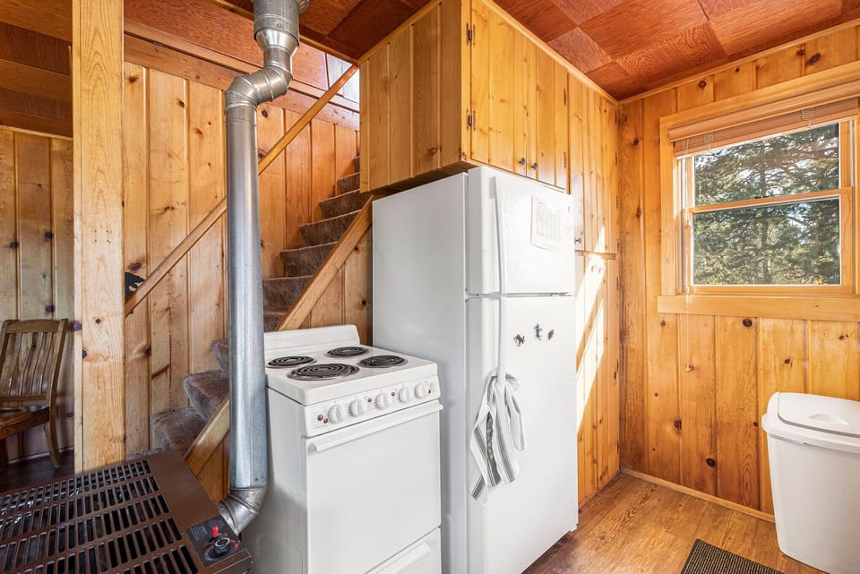 Chasm Cabin Estes Park, Kitchen with an over and full size refrigerator. Upstairs is closed off to guests.