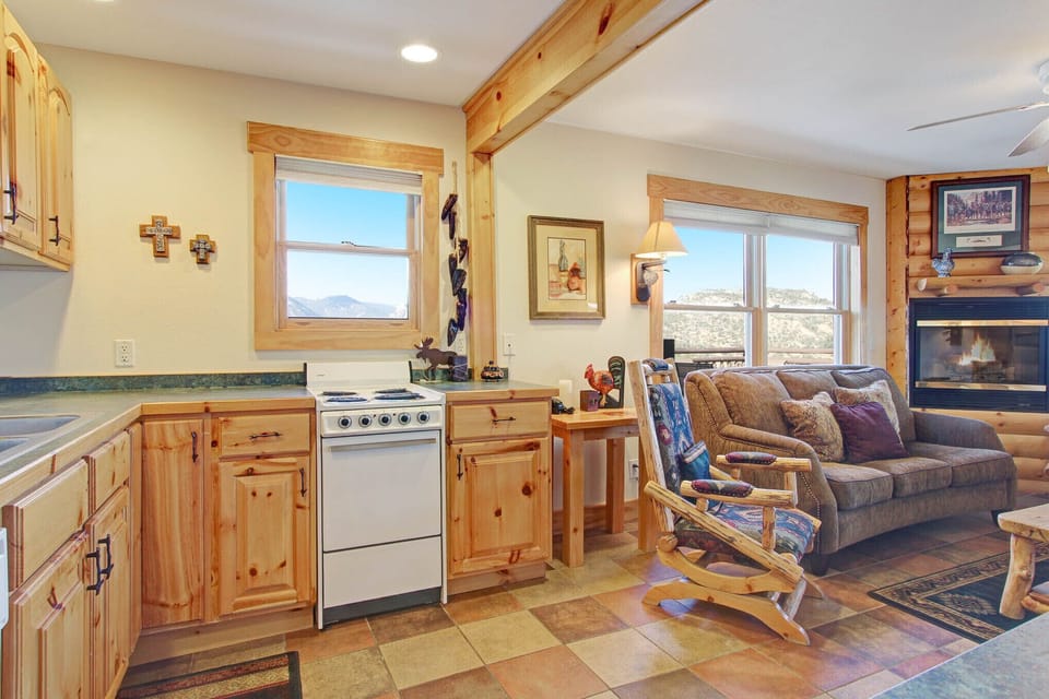 Cozy combo living/dining/kitchen space. Enjoy the mountain views and ambiance of the gas fireplace from either the log rocking chairs, three-cushion sofa, or while preparing your meals! Oven and stove top pictured.