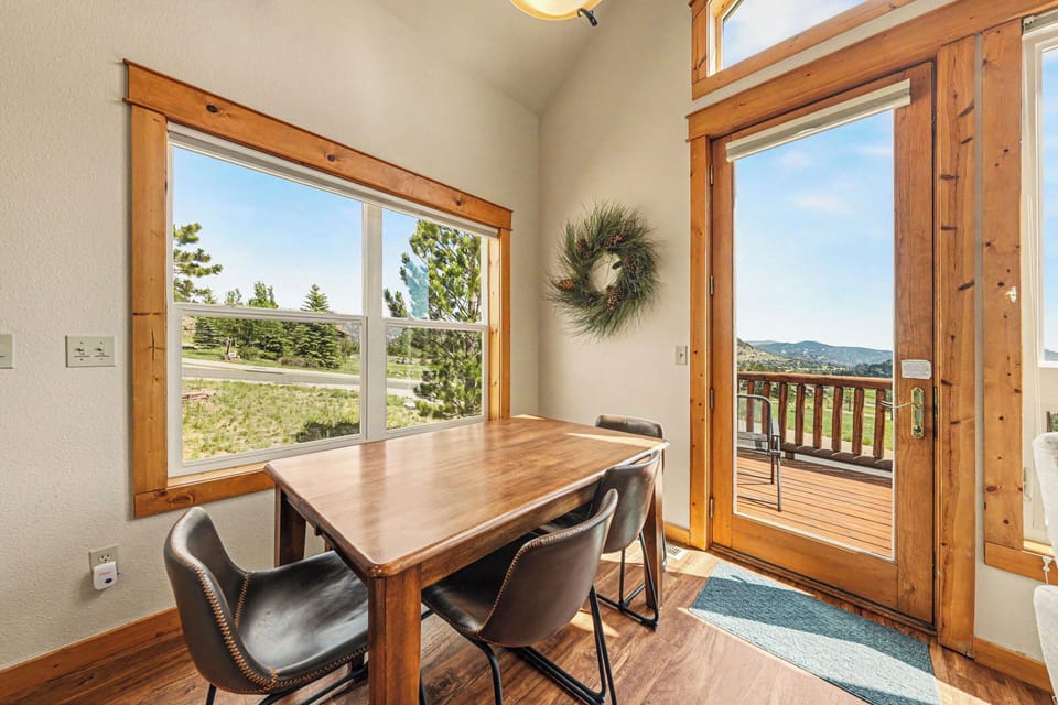 Enjoy meals at your dining table with natural light streaming through large windows and direct access to your private deck, where mountain views await just beyond the door.