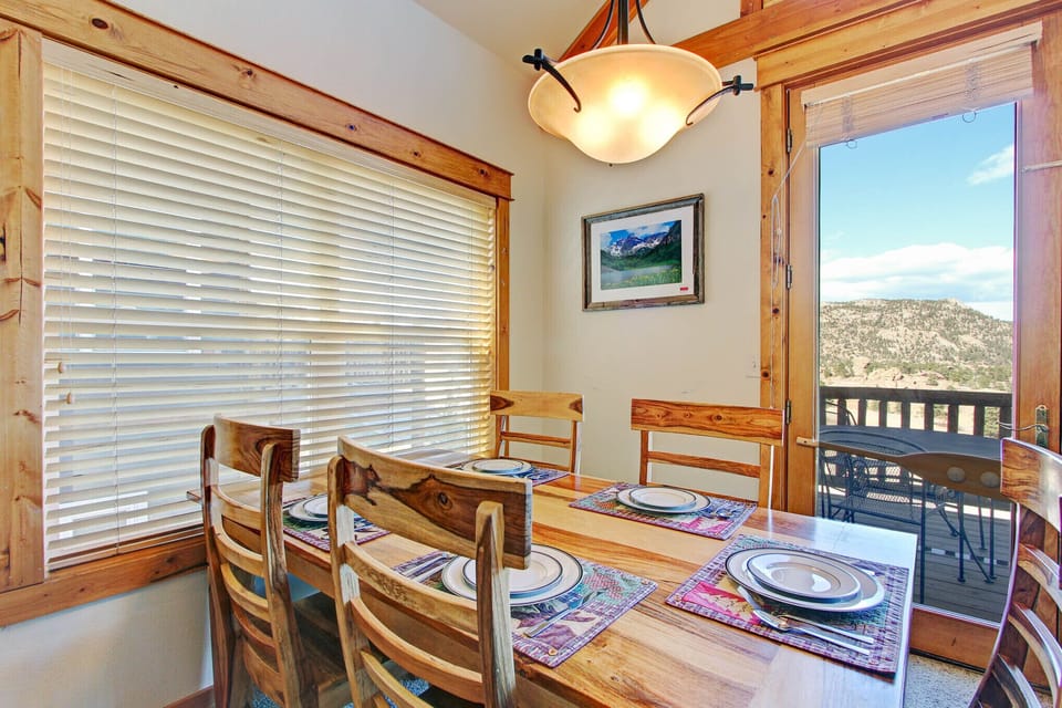 Dining room table with seating for five guests opens up to beautiful mountain views from the windows.