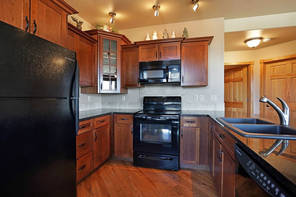 Full kitchen with glass top stove/oven, refrigerator, microwave and dishwasher. 