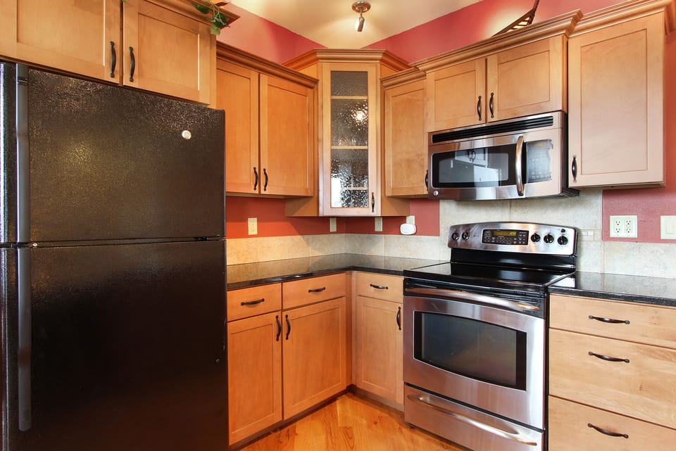 Kitchen with glass top electric stove/oven, microwave and refrigerator and lots of counter space. 