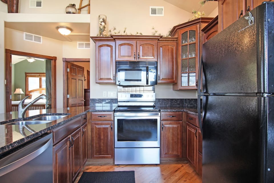 Full kitchen with dishwasher, glass top electric range, microwave, full size refrigerator. 