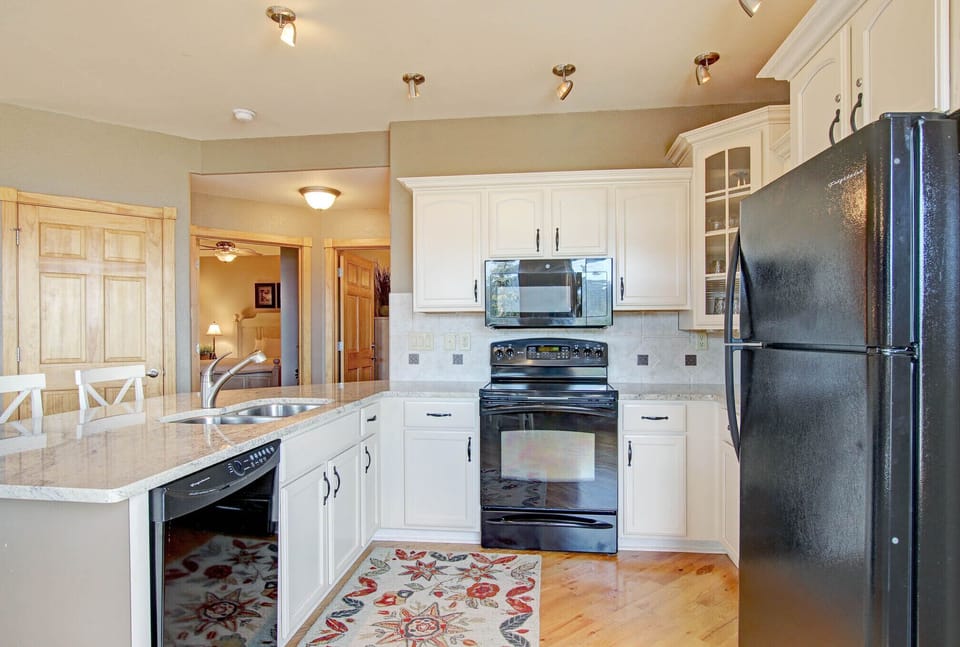 Full sized kitchen with refrigerator, electric glass top stove/oven, microwave and dishwasher. 