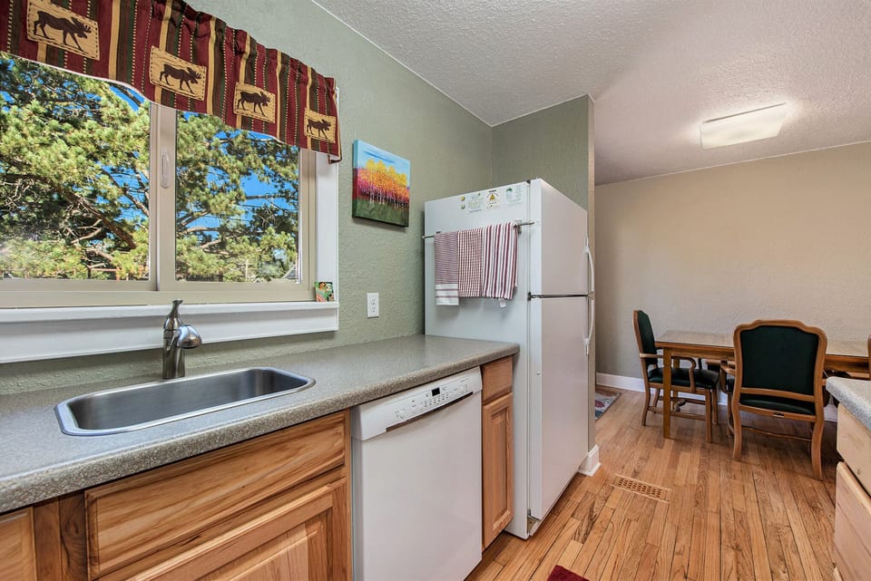 Your Vacation House Estes Park, Kitchen with sink, dishwasher and refrigerator, that opens to dining room.